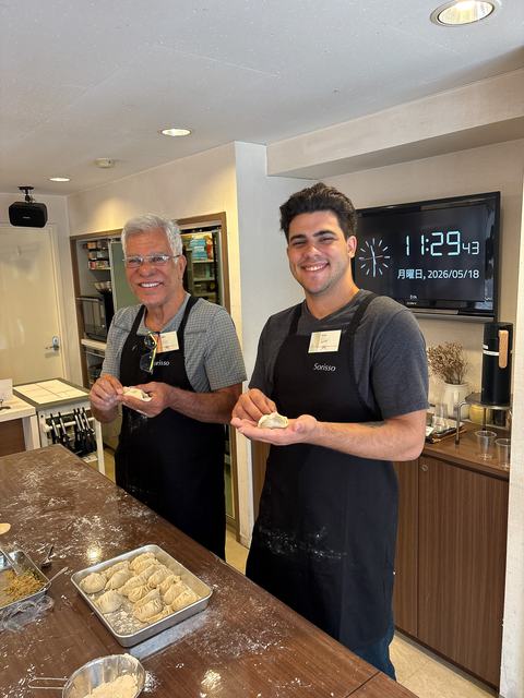 Father and son folding gyoza dumplings