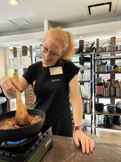 A guest stirring a pan during a cooking class