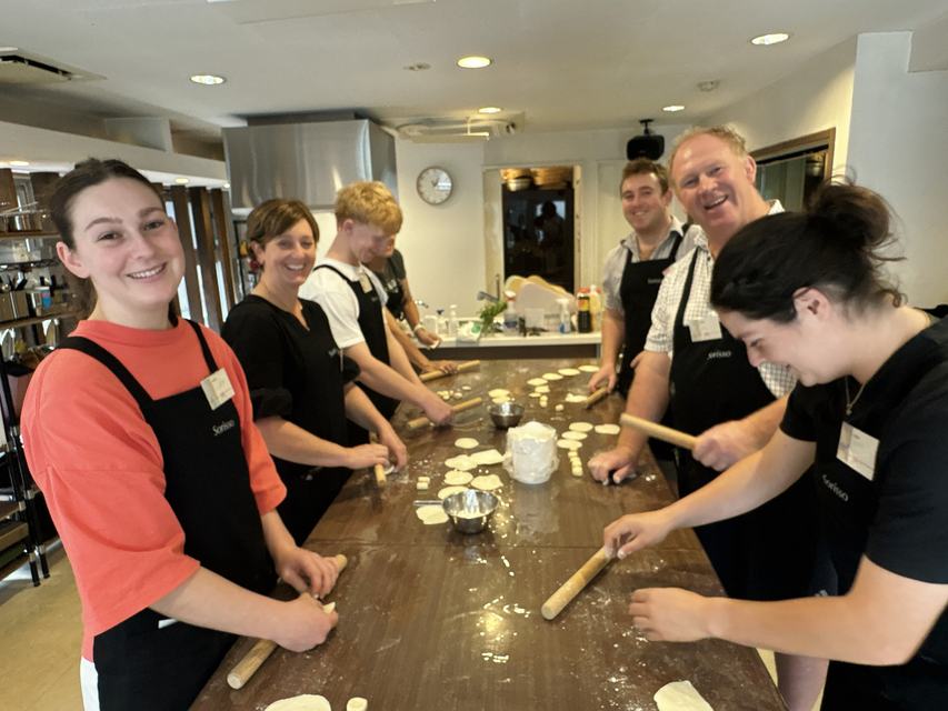 A family rolling gyoza wrappers from scratch