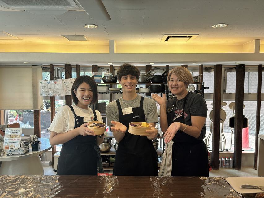 A guest and instructors with homemade bento boxes