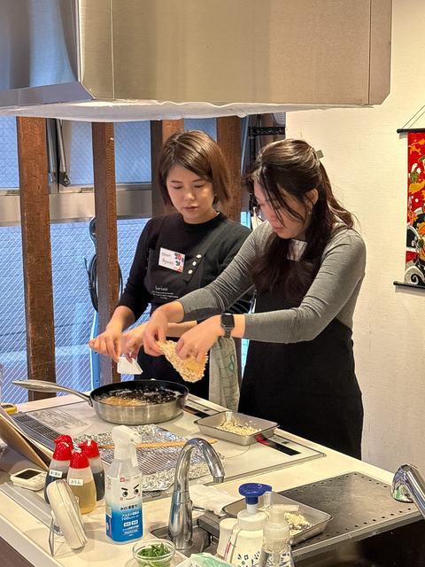 A guest frying katsu with help from the instructor